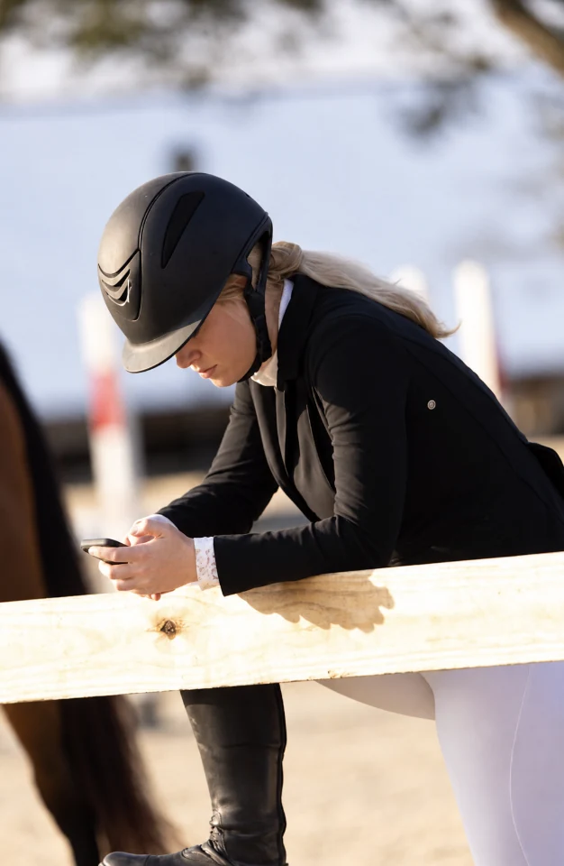 Caitlyn Levitz beside an equestrian arena